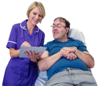 Questions A nurse standing next to a patient who is sat down. The nurse is holding a document and is asking her patient questions. They are both smiling.